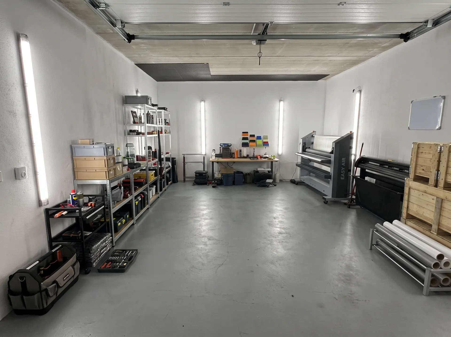 Die Werkstatthalle von Folienprofis Wien mit Laminator, Schneideplotter und Folienlager